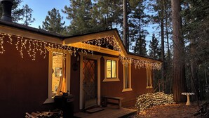 Eine Hütte mit Veranda, einer Holztür und einem Fenster.