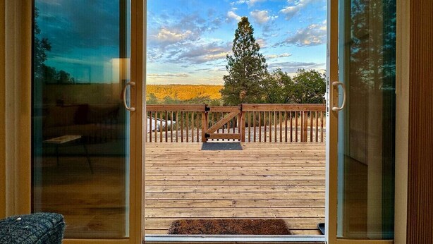 A wooden deck with a view of a tree and a clear sky. - Unique Container Home · 20 Acres · Starry Nights · EV Charger (Placerville)