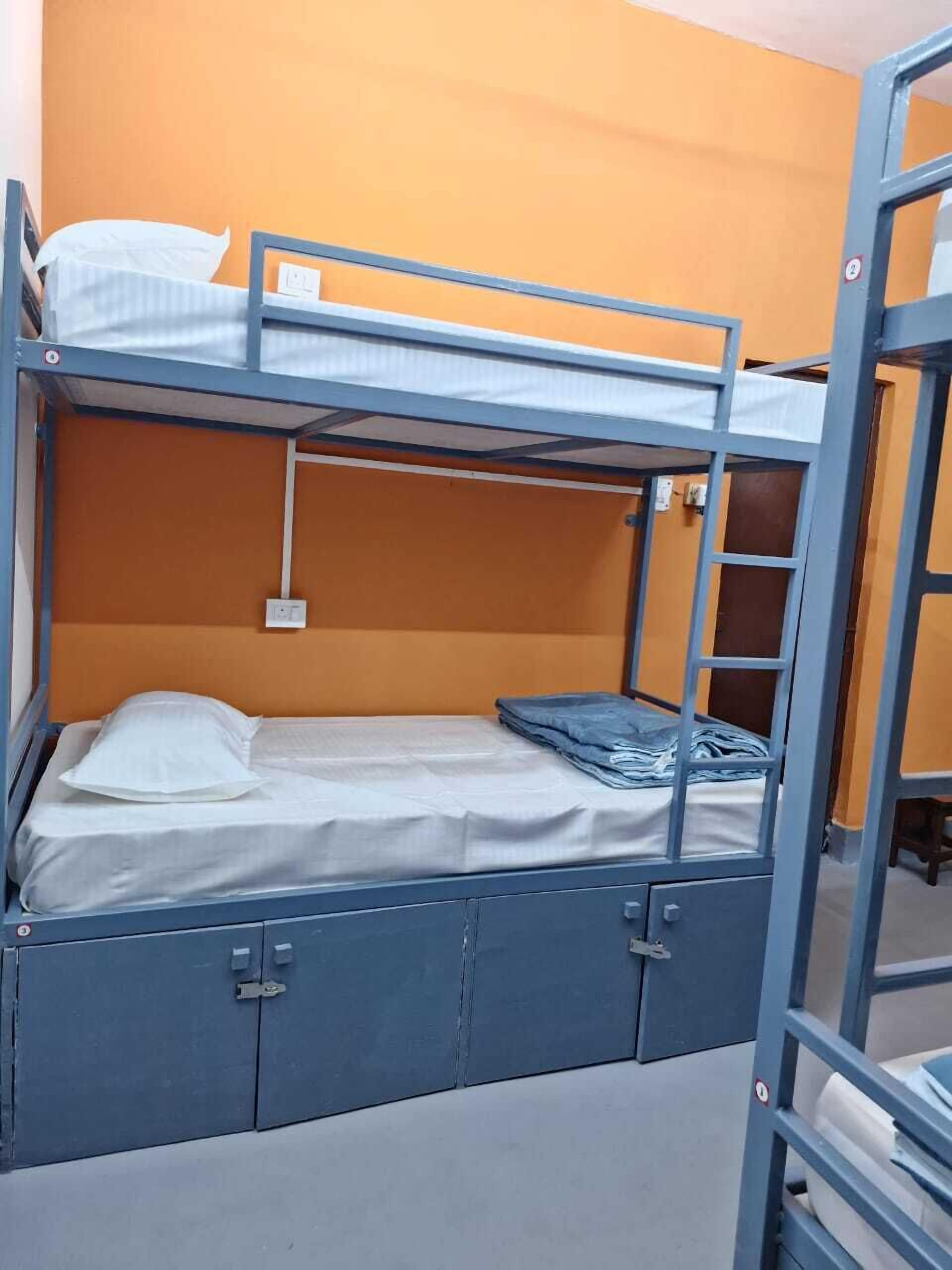 A bunk bed with a mattress, pillows, and a folded blanket.