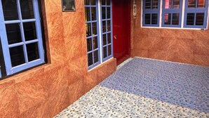 A building with a red door, blue-framed windows, and a tiled floor. - Coorg Heaven Home Stay (Madikeri)