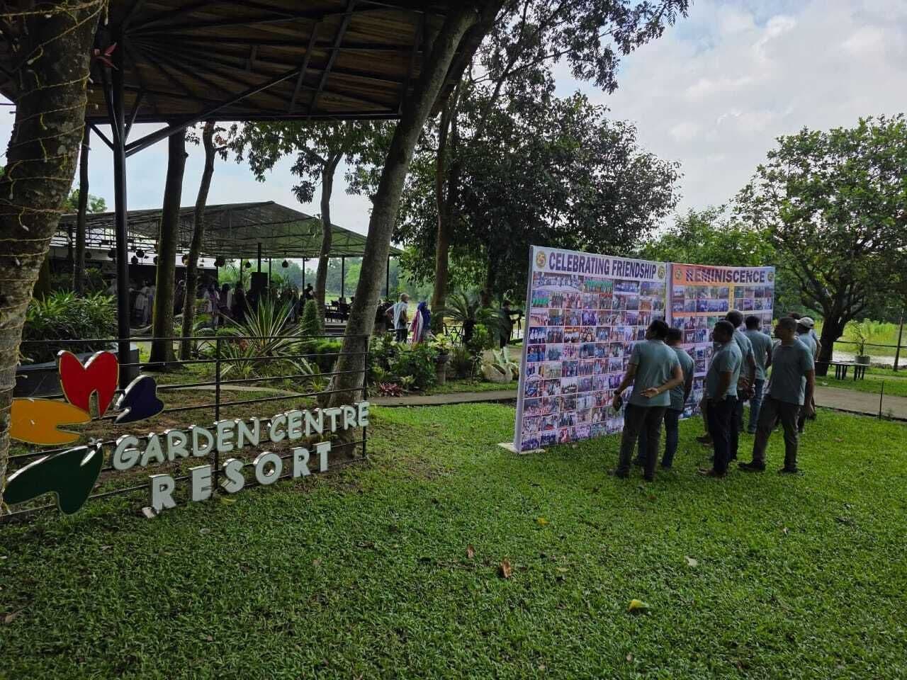 A garden centre with a signboard and a bulletin board displaying photos.