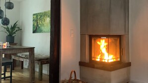 Ein modernes Wohnzimmer mit Kamin, Holzmöbeln und einem blauen Teppich.