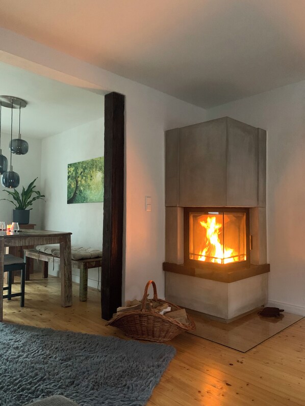 Ein modernes Wohnzimmer mit Kamin, Holzmöbeln und einem blauen Teppich.