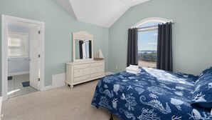 Une chambre à coucher avec un lit, une commode et une vue sur l’extérieur.