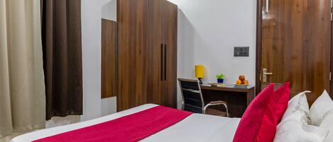 A bedroom with a bed, a desk, a chair, and a wardrobe.