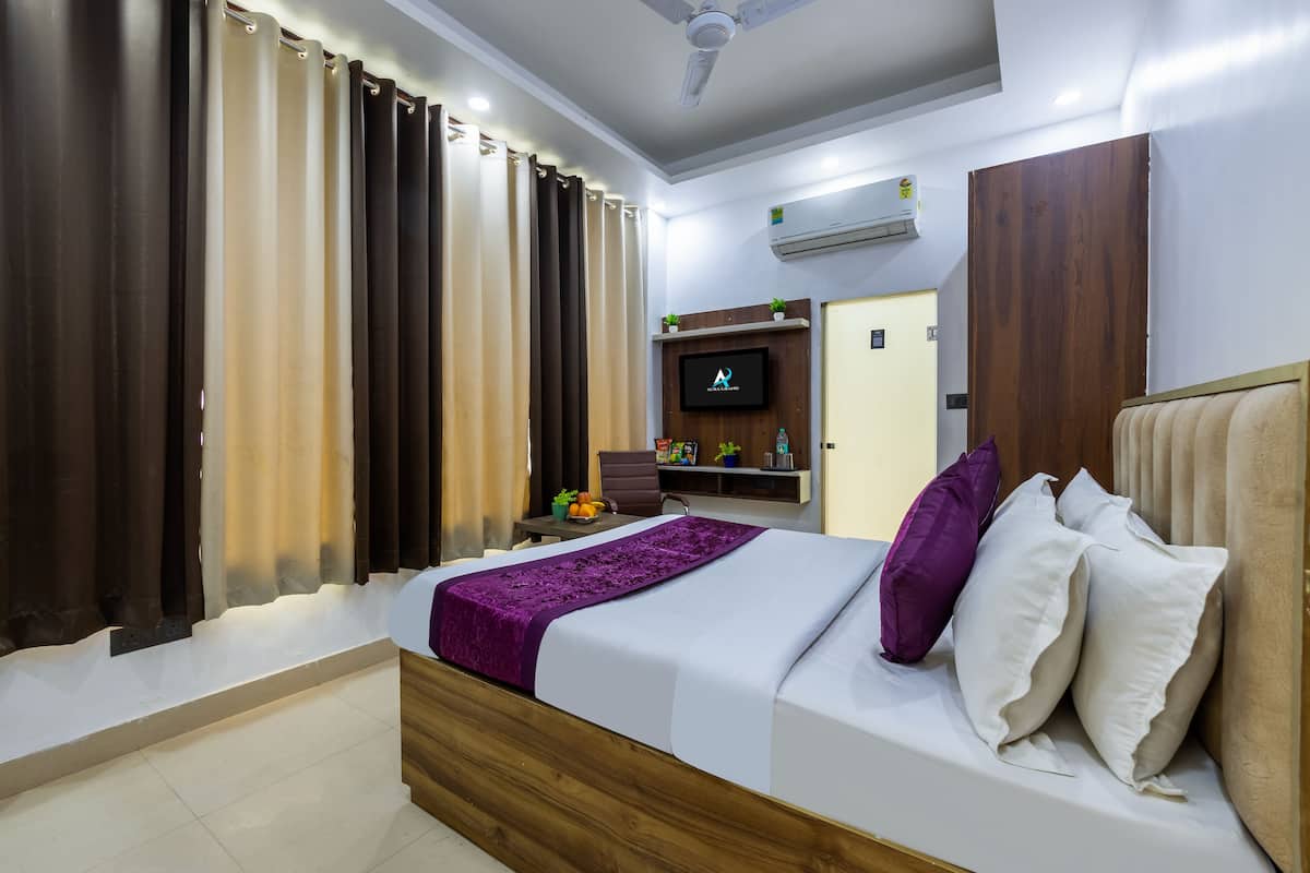 Une chambre à coucher moderne avec un lit en bois, un téléviseur à écran plat fixé au mur et un ventilateur de plafond.
