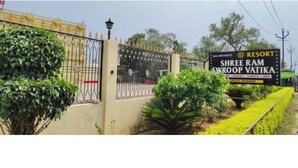 A gated entrance with a sign for Shree Ram Swroop Vatika Resort, featuring a wrought iron gate and a well-maintained garden. - Shree Ram Swaroop vatika (Karwi)