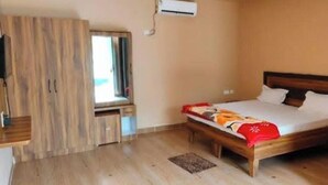 A bedroom with a wooden bed, a window, and a wardrobe. - Shree Ram Swaroop vatika (Karwi)