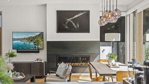Una sala moderna con chimenea, televisor y comedor.