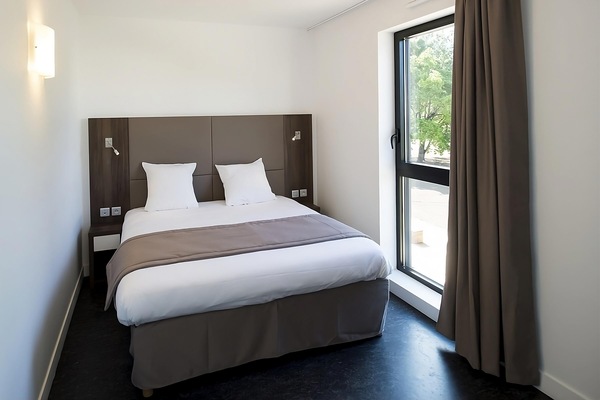 Wake up refreshed beside tall windows and calming neutral tones.