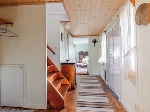 A wooden staircase leading to a bedroom with a bed, a dresser, and a window with curtains. - Ånhultaberg/Nylund by Interhome (Virserum)