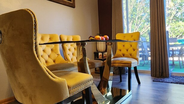 Un salon comprenant un ensemble de canapés, une table à manger et un lustre.