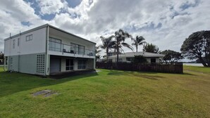 A modern two-story house with a flat roof, large windows, and a covered porch.