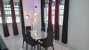 Ein Essbereich mit einem rechteckigen Tisch, sechs Stühlen und einer Vase mit Kerzen.