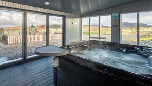 A hot tub area with a view of a playground and hills. - Wonderful private villa for 17 people with hot tub, WIFI, TV, patio and panoramic view (Daliburgh)