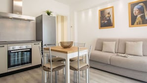 Una cucina moderna con forno integrato e zona pranzo con tavolo e sedie.