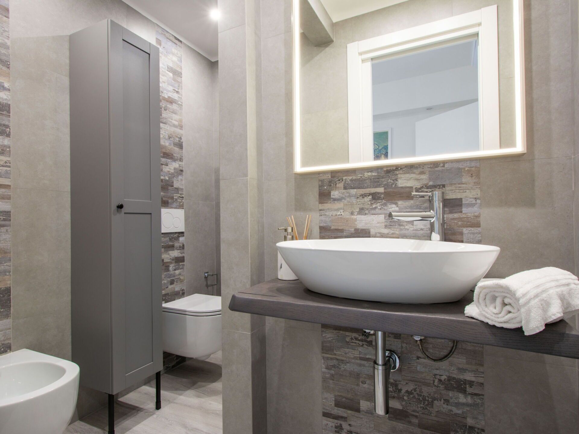 Un baño moderno con un lavabo de diseño, inodoro y zona de ducha.