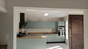 Una cocina moderna con armarios azul claro, una isla de madera y un horno empotrado.