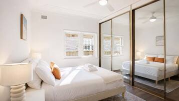 A hotel room with a bed, bedside lamp, and a large mirror.