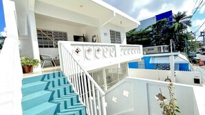 Een modern gebouw met een witte gevel, een vloer met een blauw chevrondpatroon en een witte balustrade met decoratieve details.