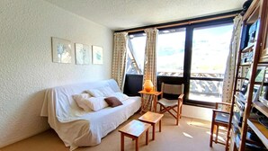 A cozy room with a white sofa, a small wooden table, a chair, and a bookshelf. - Studio cabin for 6 with balcony and equipped kitchenette in Piau-Engaly (Piau-Engaly)