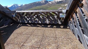 A wooden deck with a lattice railing, gravel flooring, and a view of snow-capped mountains in the background. - Studio cabin for 6 with balcony and equipped kitchenette in Piau-Engaly (Piau-Engaly)