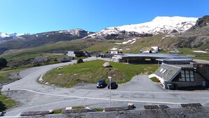 A building with a curved roof and a parking area with cars. - Studio cabin for 6 with balcony and equipped kitchenette in Piau-Engaly (Piau-Engaly)