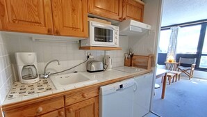 A compact kitchen with wooden cabinets, a microwave, a Bosch coffee maker, a toaster, and a dishwasher. - Studio cabin for 6 with balcony and equipped kitchenette in Piau-Engaly (Piau-Engaly)