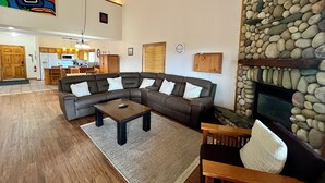 A spacious living area with a sectional sofa, a coffee table, and a fireplace. - Affordable Slope-Side: 3BR Condo w/ Private Hot Tub, Gas Fireplace, Great Location & Views. (Kimberley)