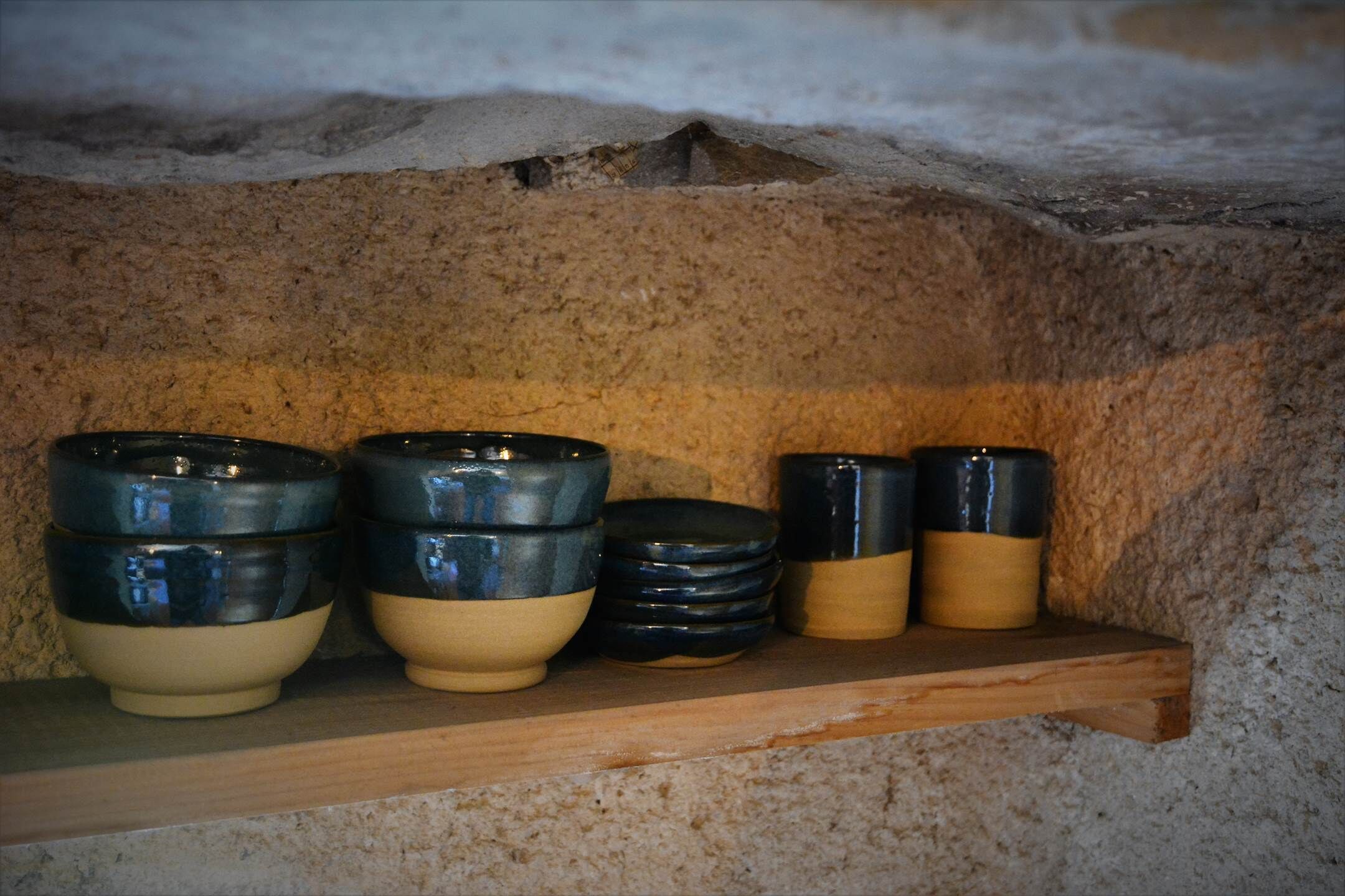 A shelf with ceramic bowls and containers.