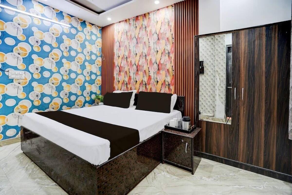 A bedroom with a bed, a nightstand, a wardrobe, and a mirror.
