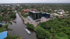 Une vue aérienne d’une ville traversée par une rivière, entourée de verdure et de bâtiments.