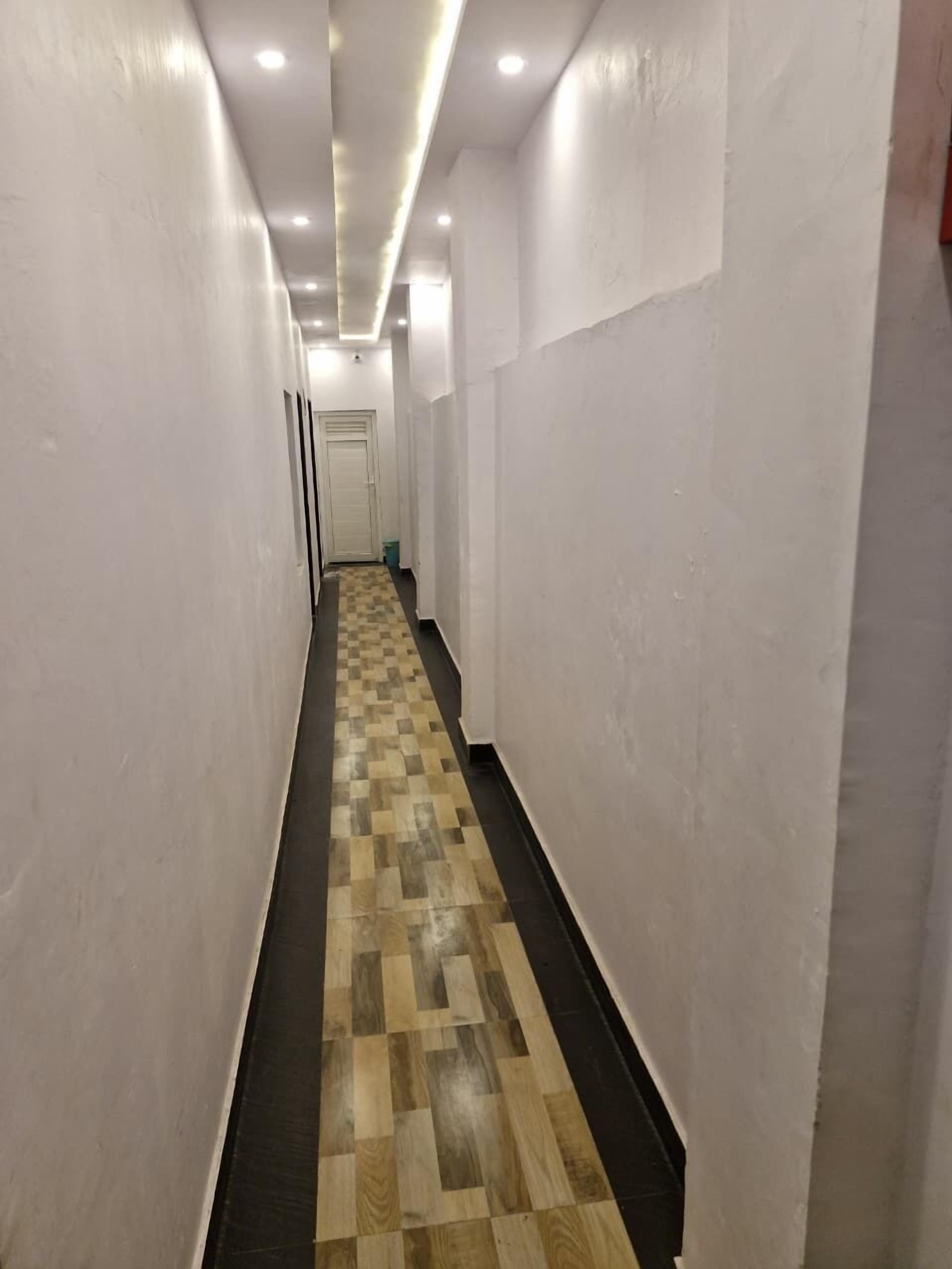 Ein schmaler Gang mit Schottenmuster-Holzboden und weißen Wänden.