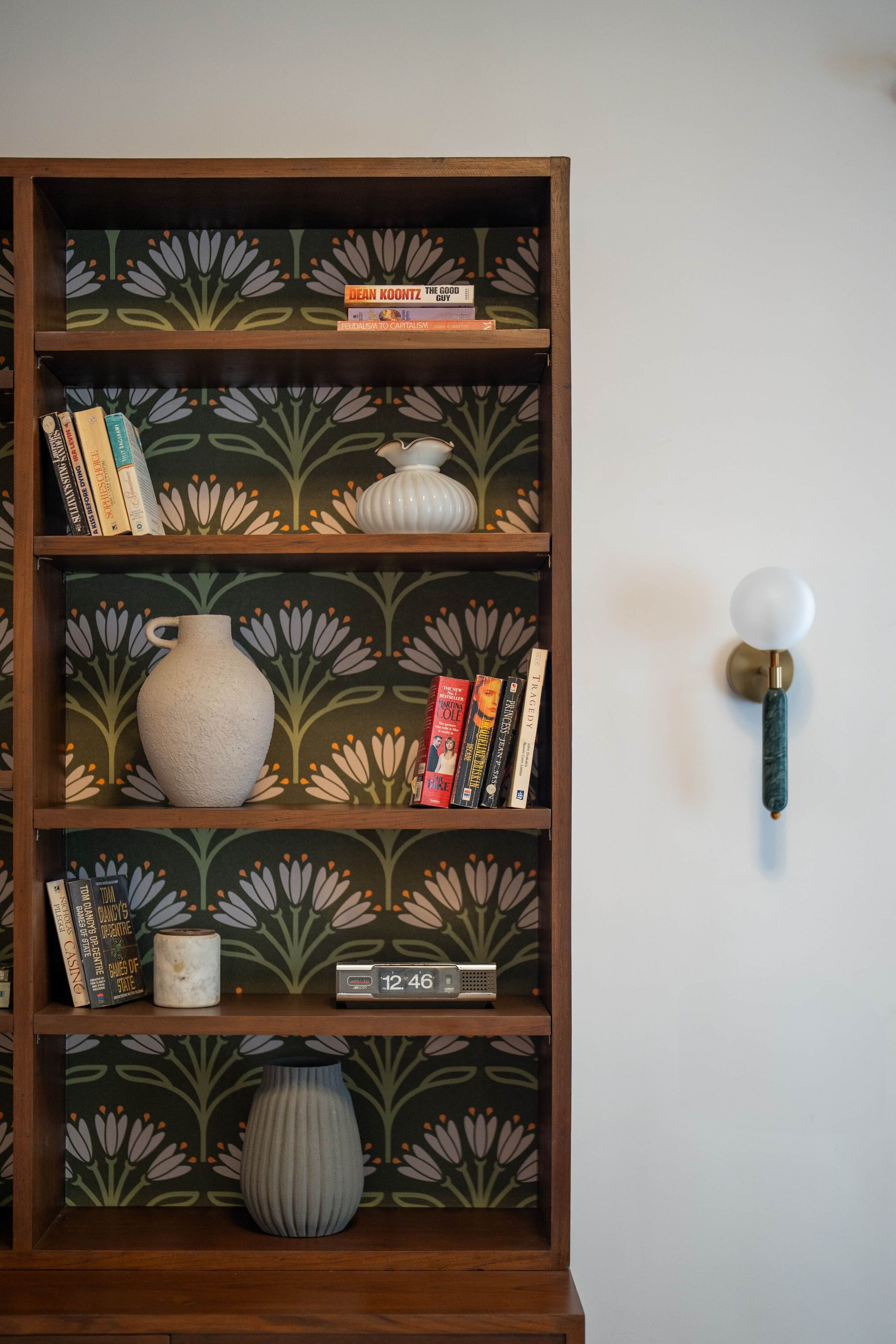 A bookshelf with decorative vases and books.