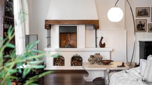 A cozy living room with a fireplace, a table with decorative items, and a bookshelf. - The Vintage Sunshine (Cairo)