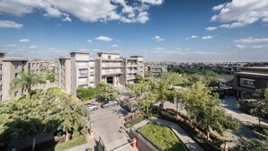 A residential complex with multiple apartment buildings, a parking area, and green spaces. - New Giza’s Boho Bliss (6th of October City)