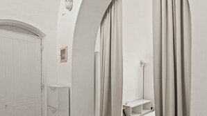 Um corredor com uma porta, um armário e uma estante, tudo em branco.