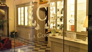 A hotel lobby with a checkered floor, a reception desk, and a glass wall with a logo. - La Corte Di Ambra Historical House - Historical Center of Cortona (Cortona)