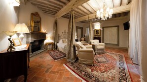 A traditional living room with a fireplace, leather armchairs, and a patterned rug. - La Corte Di Ambra Historical House - Historical Center of Cortona (Cortona)