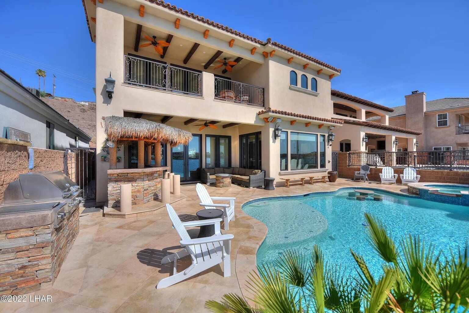 Une maison à deux étages avec une piscine, un espace extérieur aménagé et un coin barbecue.