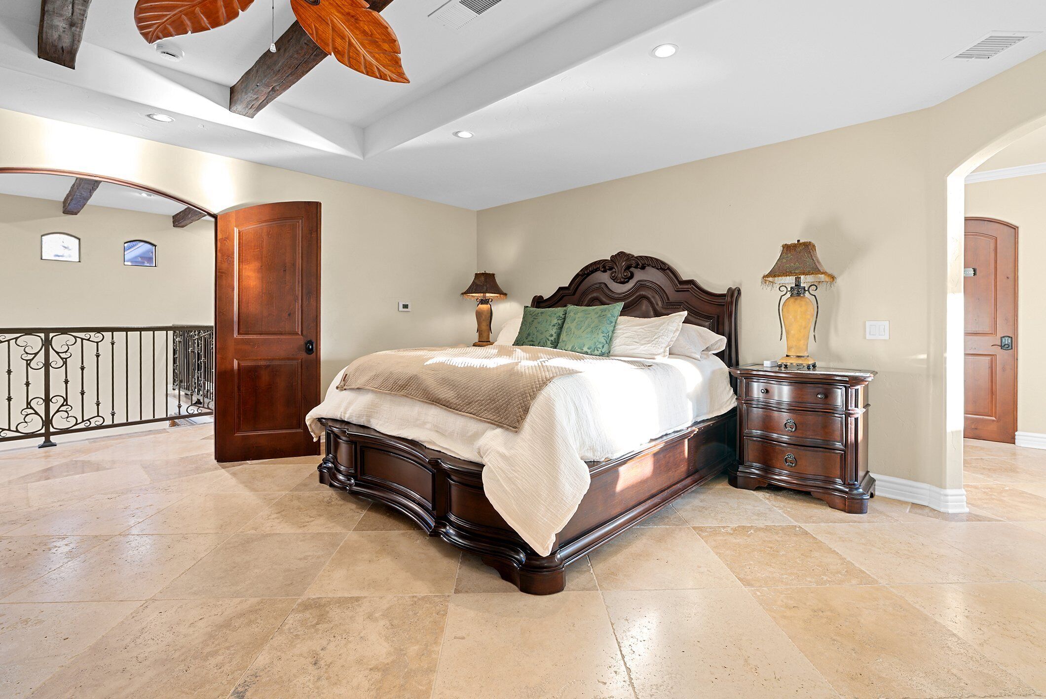 Une chambre spacieuse avec un grand lit, une table de chevet et une commode en bois.
