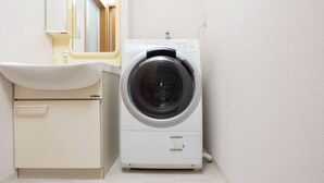 A compact, modern laundry room with a built-in washing machine and a sink. - Maison Raffine (Osaka)