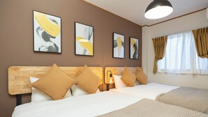 A hotel room with a wooden headboard, multiple beds, and artwork on the wall. - Maison Raffine (Osaka)