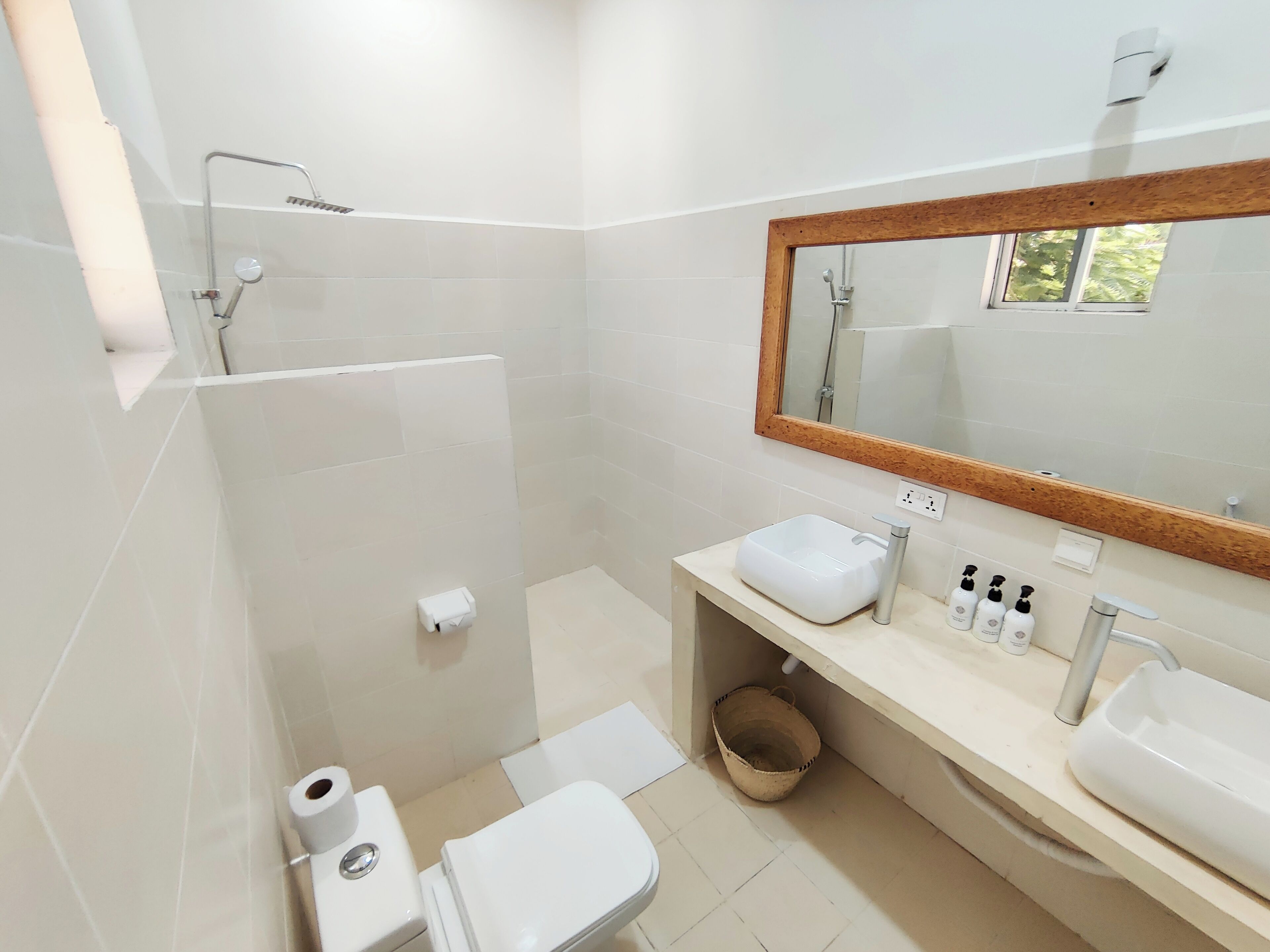 Ein modernes Badezimmer mit Dusche, Toilette, Waschbecken und Spiegel.