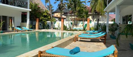 A pool area with lounge chairs and a clear view of the pool.