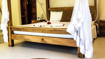 A wooden bed with a canopy, a wooden bench, and a wooden door in the background.