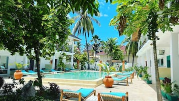 Una piscina al aire libre, tumbonas