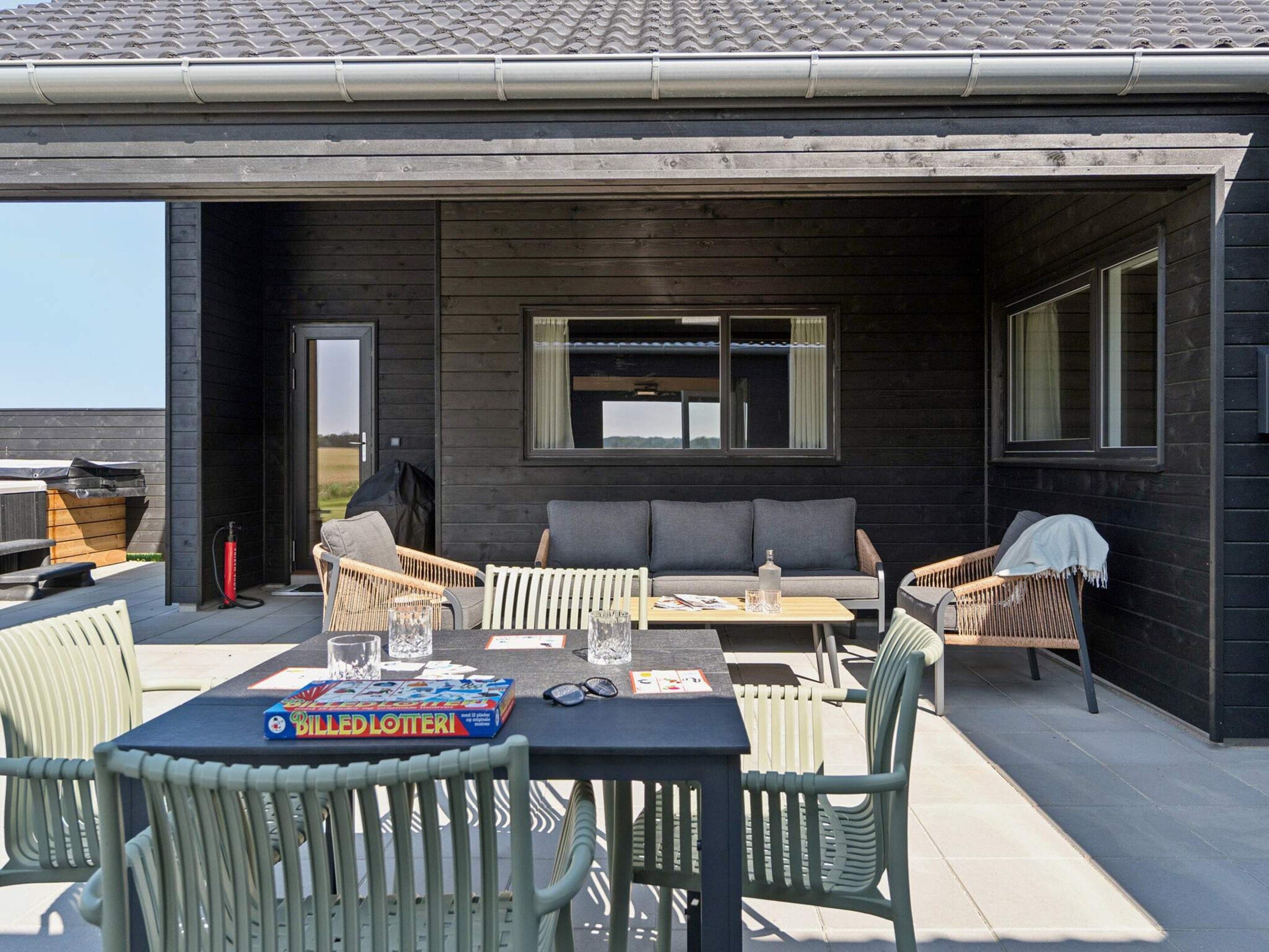 An outdoor patio with a table, chairs, and a sofa.