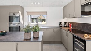 Una cucina moderna con elettrodomestici integrati, un'ampia finestra e vista sull'esterno.
