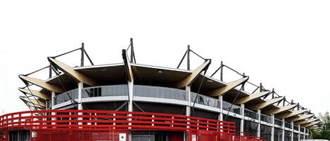 A stadium with tiered seating and a red barrier.